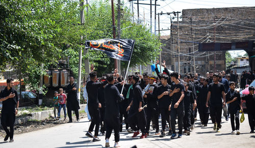 Group of people walking on road in city