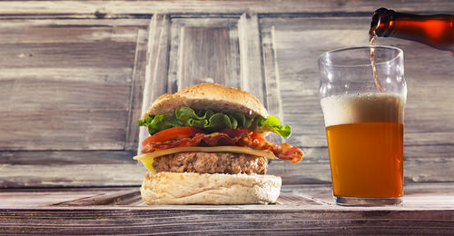 Close-up of burger and drink served on table