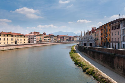 River amidst buildings in town against sky