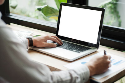 Low angle view of man using laptop on table