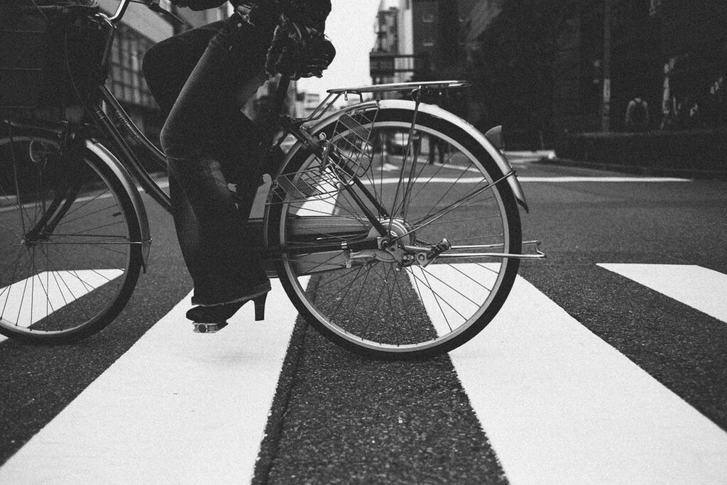 LOW SECTION OF MAN RIDING BICYCLE ON ROAD IN CITY