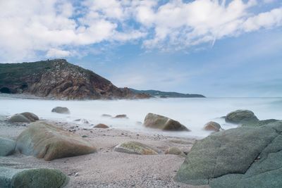 Rocks on beach against sky