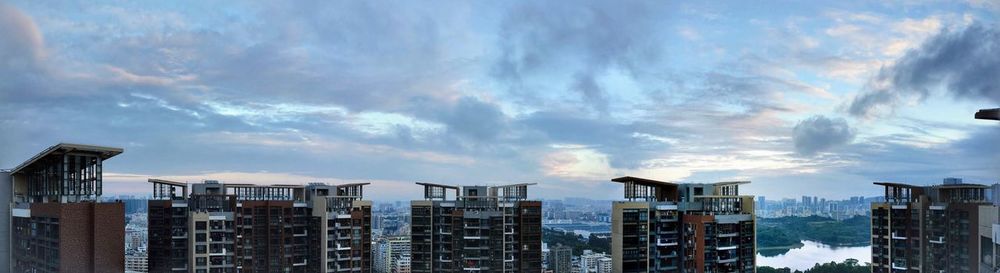Panoramic view of city against cloudy sky