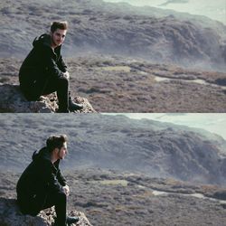 Side view of man standing on rock by sea