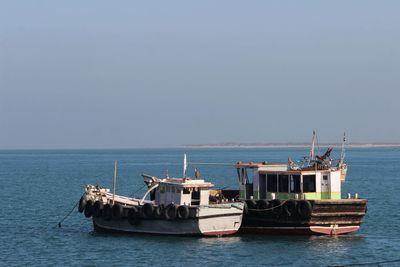 Boats in the sea against a clear sky