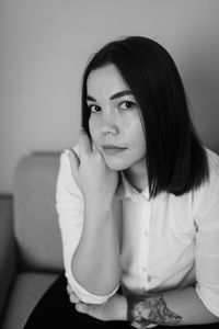 Portrait of young woman sitting at home