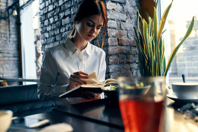 Woman looking at camera while sitting in restaurant