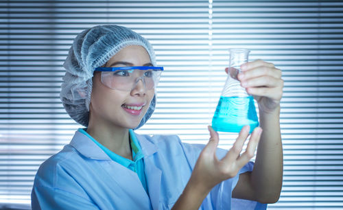 Woman examining chemical in laboratory