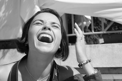 Young woman laughing outdoors