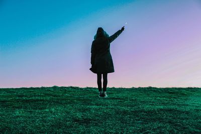 Woman standing on landscape against sky