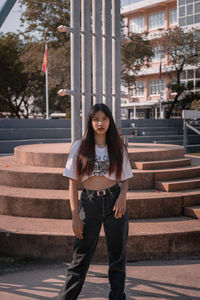 Portrait of beautiful young woman standing in city