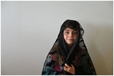 Portrait of girl against white wall