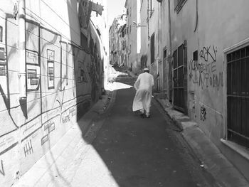 Rear view of man walking on street in city