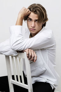 Portrait of young man sitting on chair