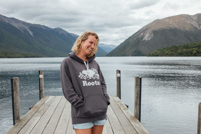 Man standing on lake against mountains