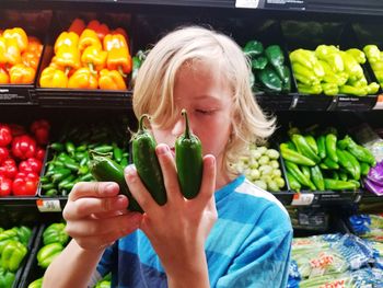 Baby girl holding vegetables in market