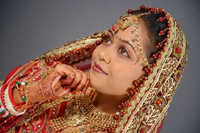 Smiling bride looking away against gray background