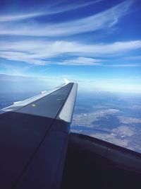 Close-up of airplane wing over sea against sky