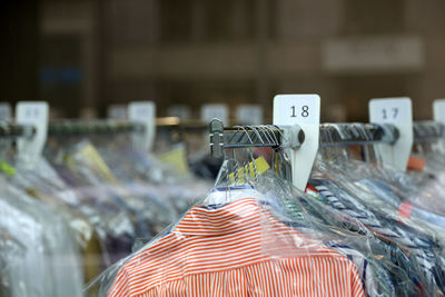 Close-up of clothes hanging on display at chemical cleaners 