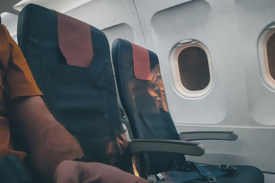 Midsection of man sitting in airplane