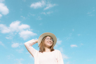 Low angle view of young woman against sky