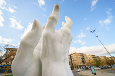 Close-up of hand against sky