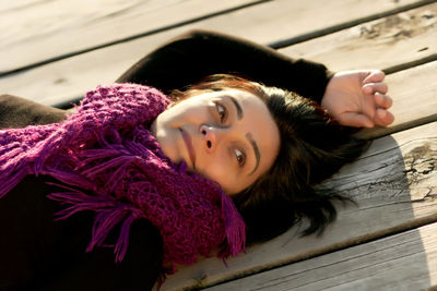 Smiling woman lying on boardwalk