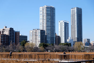 Skyscrapers in city against blue sky