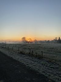 Scenic view of field against clear sky during sunset