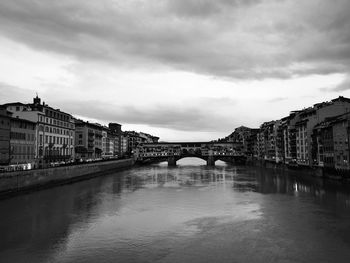 Bridge over river in city against sky