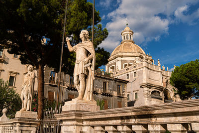 Low angle view of statue against historic building