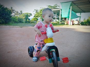 Full length of cute boy riding toy car