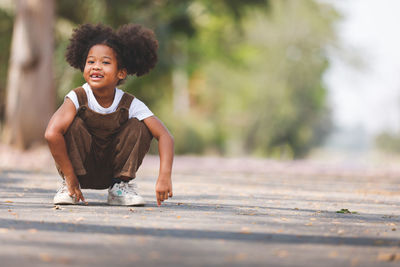 Portrait of smiling girl sitting outdoors