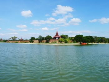 Scenic view of river against cloudy sky