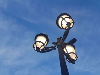 Low angle view of illuminated street light against sky