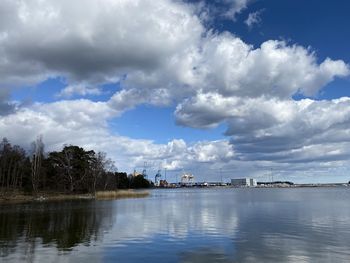 Scenic view of river by buildings against sky