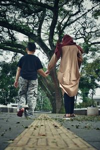 Rear view of people walking on road