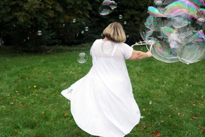 Rear view of woman standing on grass