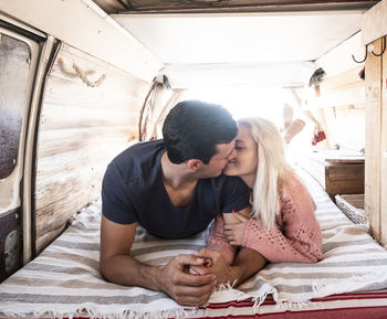 Young couple kissing while lying in motor home