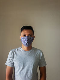 Portrait of man wearing mask against wall
