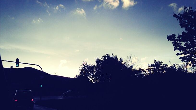 silhouette, sky, tree, transportation, low angle view, car, land vehicle, cloud - sky, street light, road, sunset, dusk, cloud, mode of transport, nature, outdoors, street, blue, no people, growth