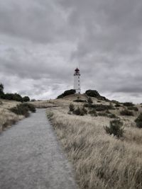 Low angle view of lighthouse amidst plants against sky