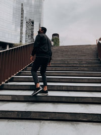 Rear view of man standing on staircase