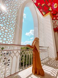 Rear view of woman standing in temple against building