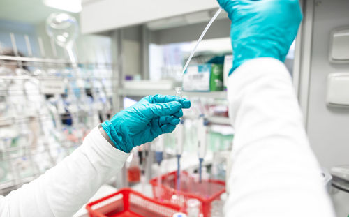 Cropped hand of scientist pipetting in laboratory