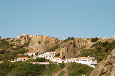 Townscape by mountain against clear blue sky