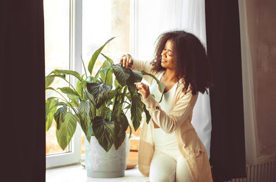 Side view of young woman holding flower