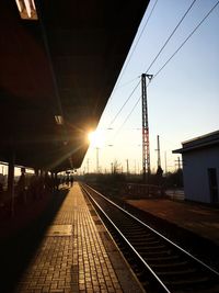 Railway tracks against clear sky at sunset