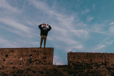 Low angle view of man standing against sky