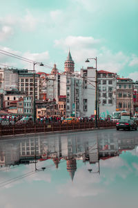 Reflection of buildings in puddle on road